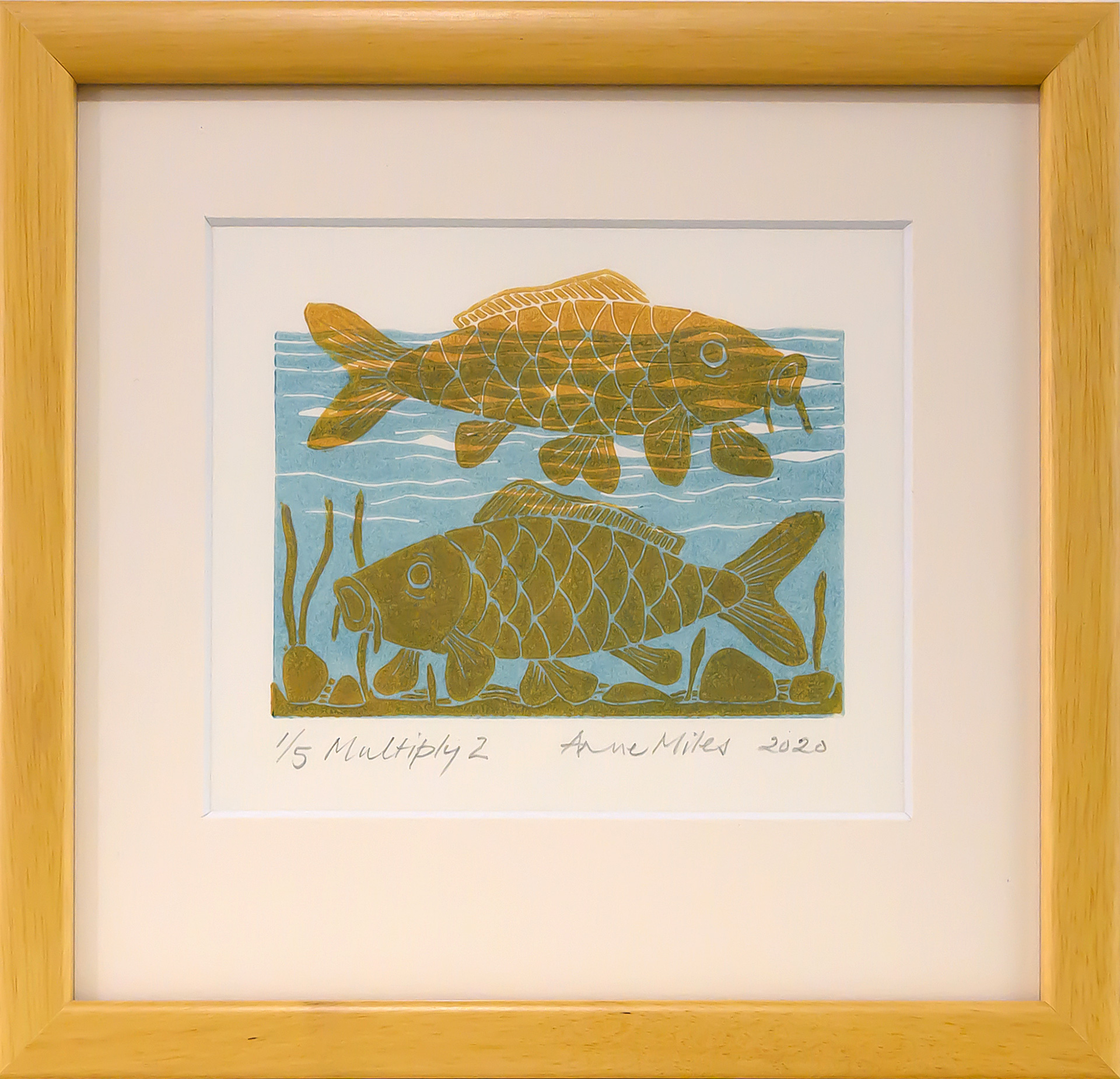 Framed artwork by Anne Miles of 2 yellow Carp with rocks and weeds in a blue water background