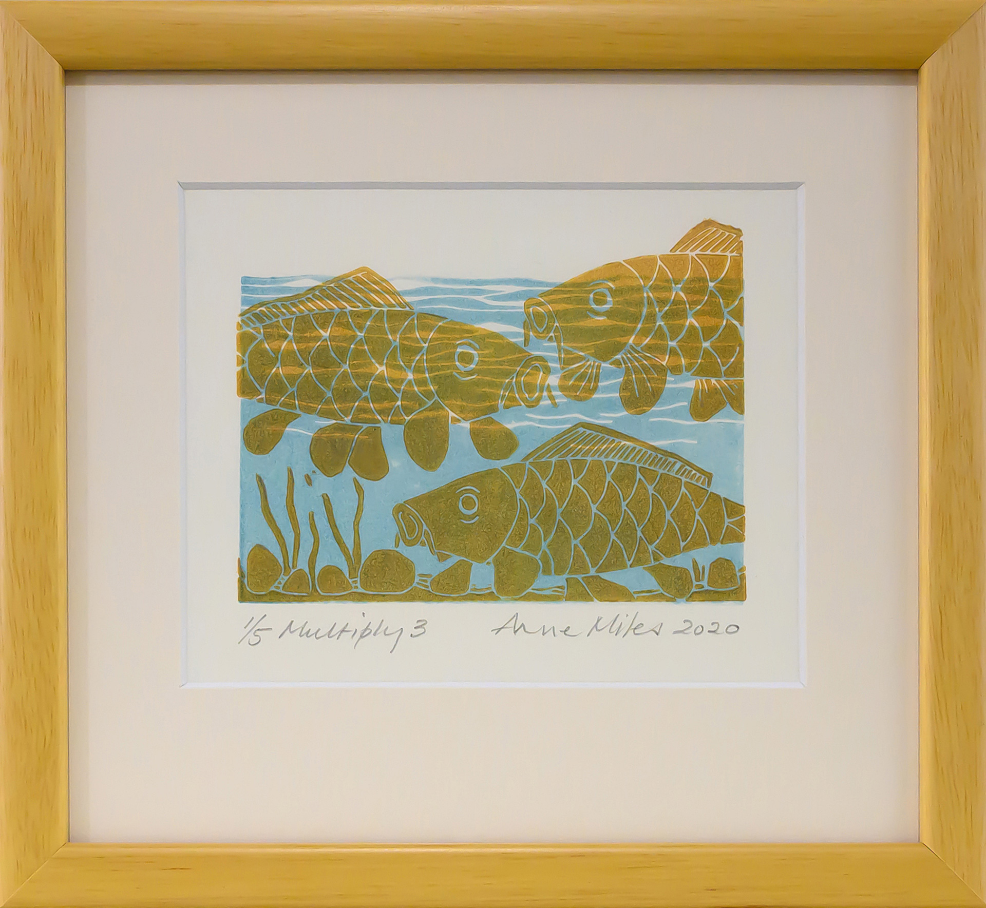 Framed artwork by Anne Miles of 3 yellow Carp with rocks and weeds in a blue water background