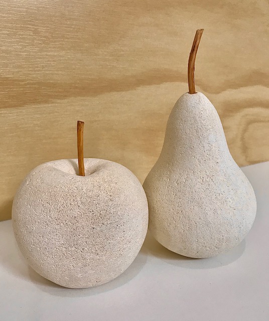 Limestone life size apple and pear sculptures with applewood stems.