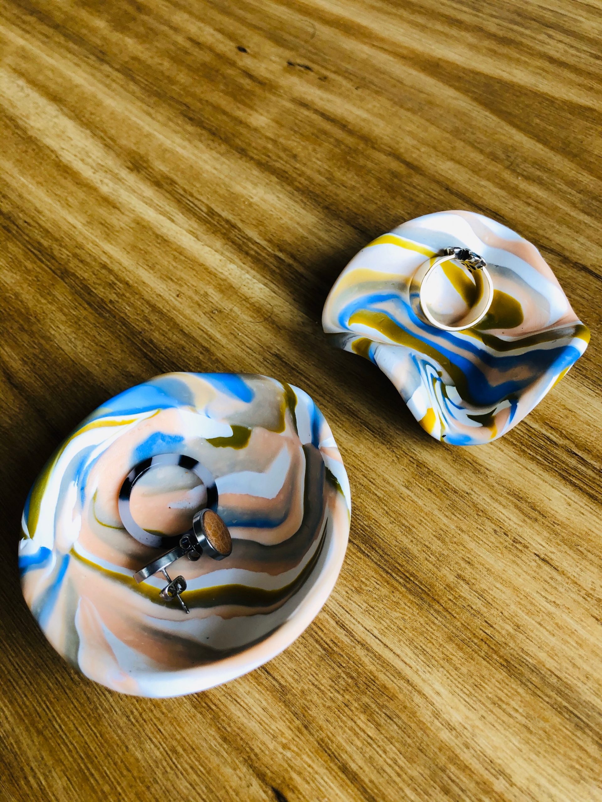 Colourful marbled polymer clay bowls holding rings