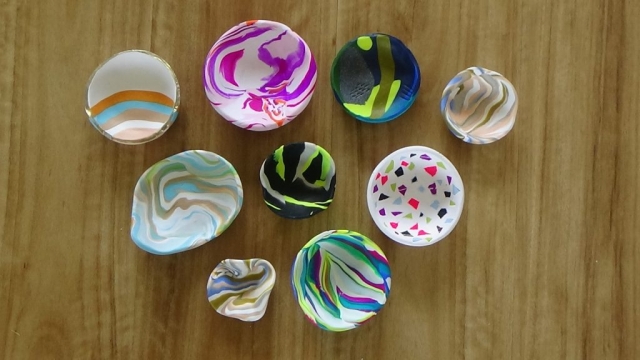 Many differently coloured marbled polymer clay bowls.